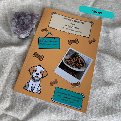Coverbild von Anettes Rezepte für 4 Pfoten – Hundeleckerli-Rezepte für den Thermomix® mit Foto von Hundekeksen und Illustration eines Hundes.